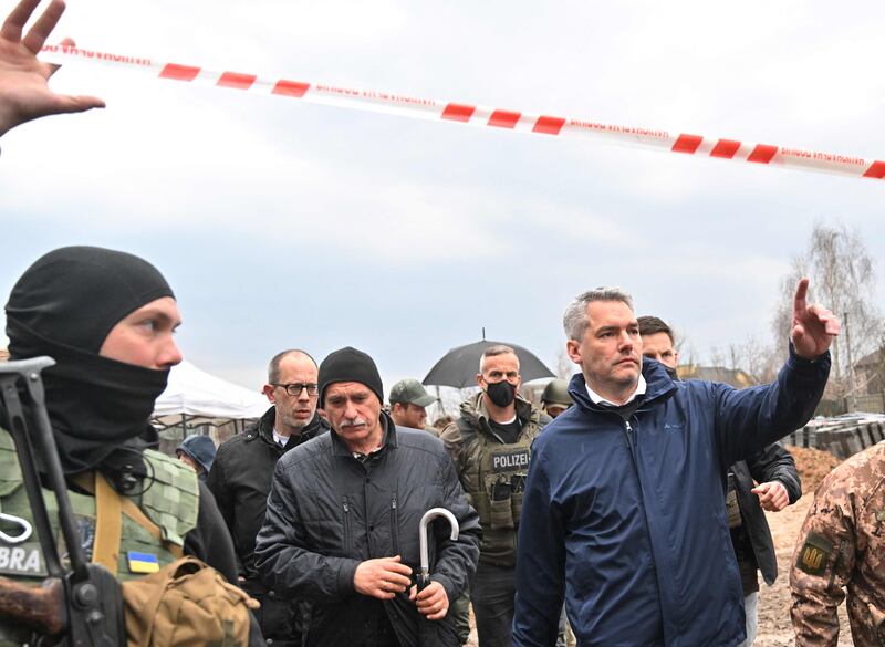 Austrian Chancellor Karl Nehammer, right, leaves after visiting the site of a mass grave in the Ukrainian town of Bucha, on April 9. AFP