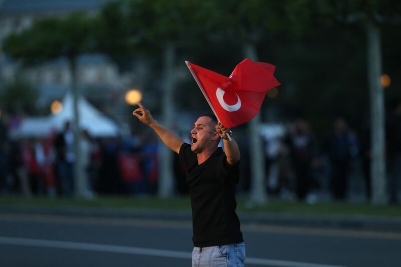 A man waves a Turkish flag outside the presidential palace in Ankara. EPA