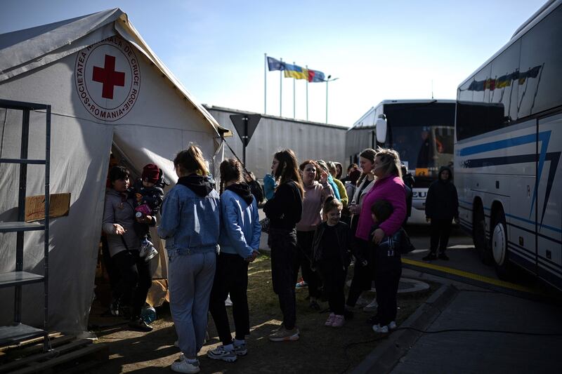 A Ukrainian refugee holds her baby as she walks out of a Romanian Red Cross tent at the Isaccea border crossing, north-eastern Romania. AFP