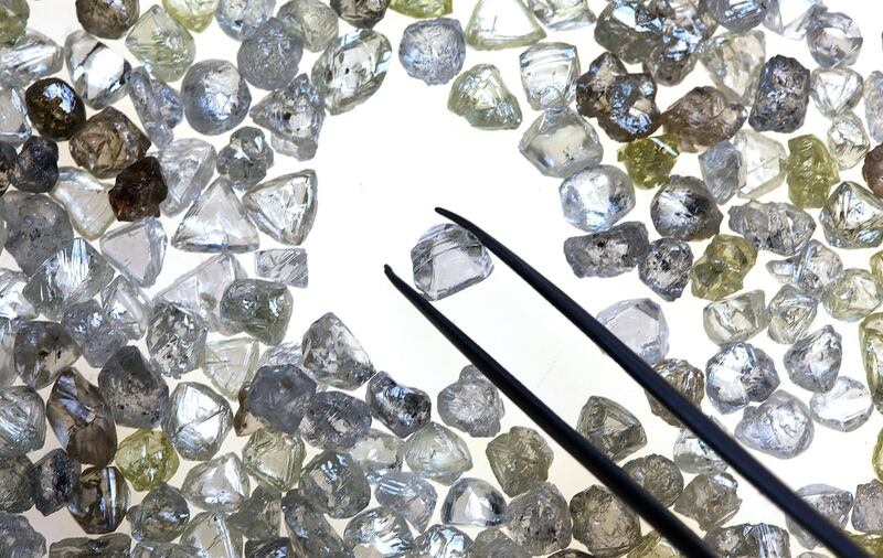 An uncut diamond is selected from a pile of colorless and colored diamonds on a sorting table at DTC Botswana, a unit of De Beers, in Gaborone, Botswana, on Thursday, Oct. 25, 2012. XXX SECOND SENTENCE HERE XXX. Photographer: Chris Ratcliffe/Bloomberg
