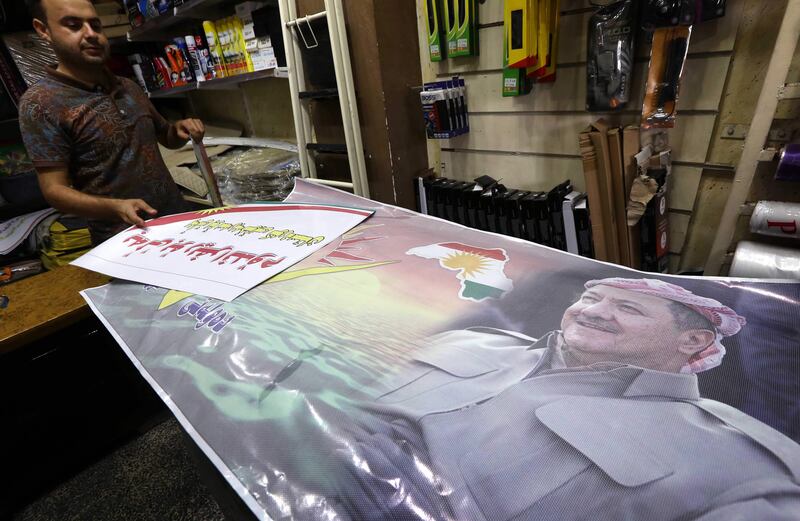 An Iraqi Kurdish man shows posters at a shop bearing images of Iraqi Kurdish leader Massud Barzani and urging people to vote ahead of the upcoming independence referendum in Arbil, the capital of the autonomous Kurdish region of northern Iraq, on September 7, 2017. 
Iraq's autonomous Kurdish region will hold a historic referendum on statehood in September 2017, despite opposition to independence from Baghdad and possibly beyond.  / AFP PHOTO / SAFIN HAMED