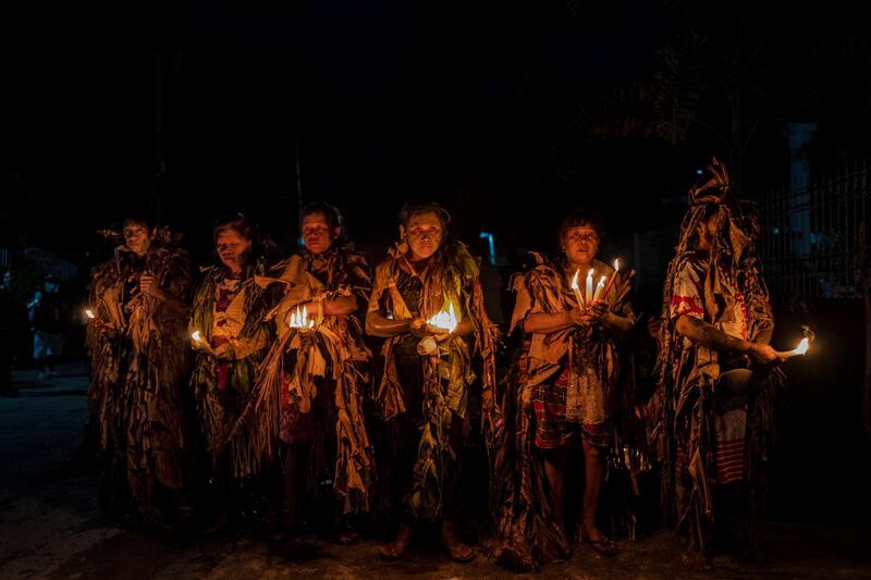 Devotees covered in mud and dried banana leaves light candles and pray outside a closed church to celebrate the Taong Putik (mud people) Festival in the village of Bibiclat in Aliaga, Nueva Ecija province, Philippines. Each year, the residents of Bibiclat celebrate the Feast of St John in a little-known Catholic festival that traces its history from the Second World War and tells how rain stopped the killing of 14 villagers by Japanese soldiers in 1944. Getty