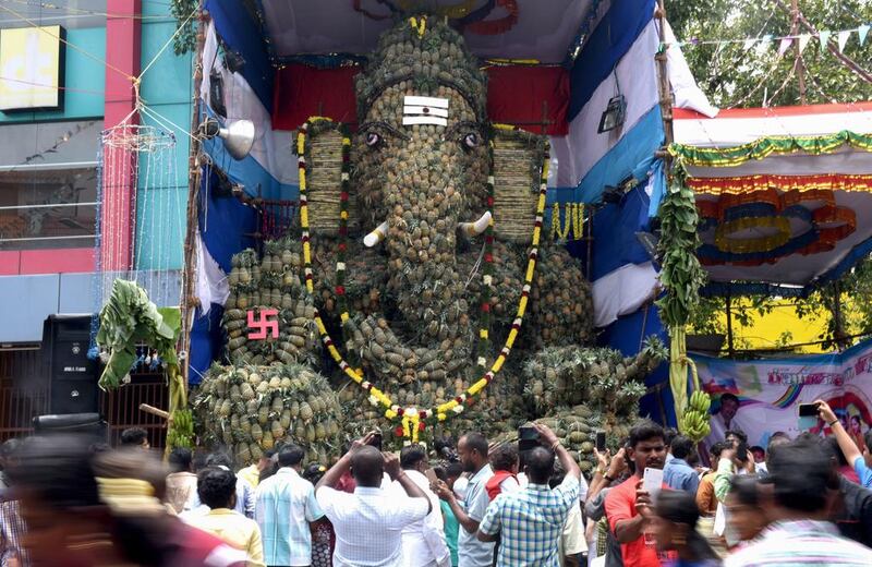 Hindu devotees gather in front of a statue of the elephant-headed Hindu god Ganesha, made out 3.5 tons of pineapples, during the Ganesh Chaturthi festival in Chennai.  Arun Sankar / AFP