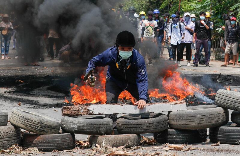 A man stands behind a barricade during a protest against the military coup in Yangon. Reuters