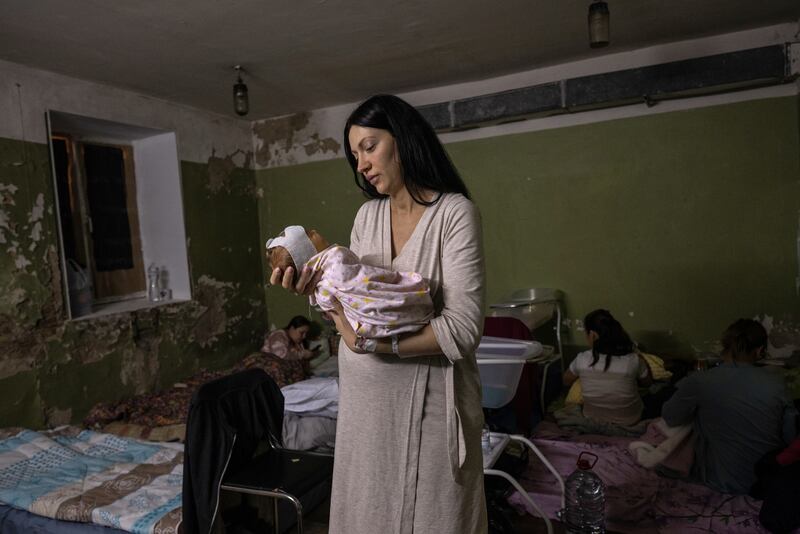 A Ukrainian mother tends to her newborn child in a basement maternity ward, as Russian forces fight Ukrainian defenders on the outskirts of Ukraine's capital Kyiv, in March 2022.