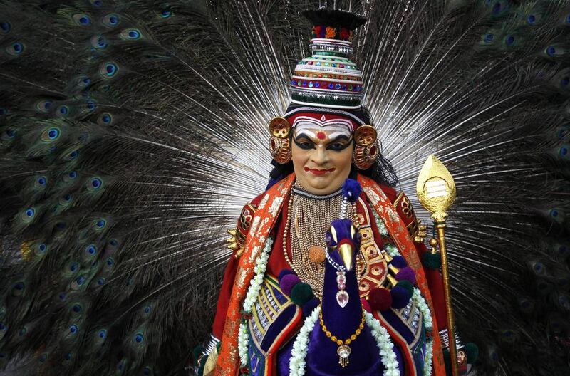 An Indian folk artist dressed as the Hindu god Muruga waits to perform during Kummattikali, as a part of Onam. AP