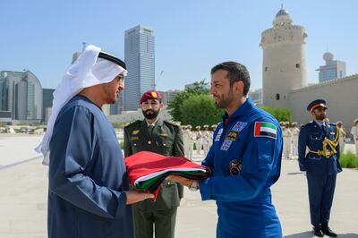 President Sheikh Mohamed is presented with the UAE flag by UAE astronaut Sultan Al Neyadi during a Flag Day ceremony, at Qasr Al Hosn. Photo: Presidential Court
