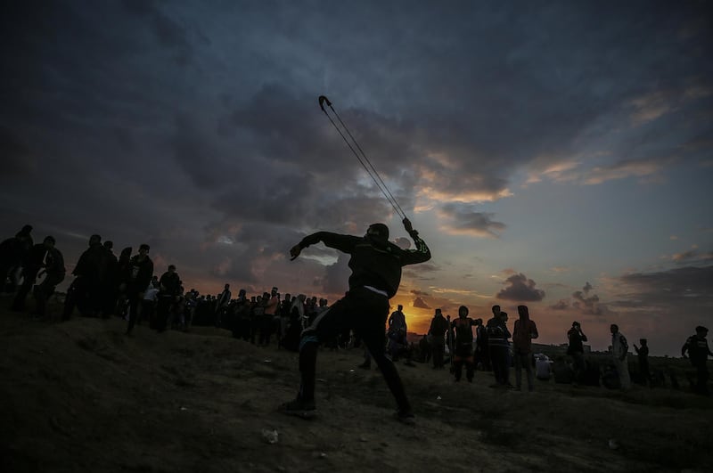 epaselect epa07170725 Palestinian protesters throw stones at Israeli troops during the clashes after Friday protests near the border between Israel and Gaza Strip in the east Gaza Strip, 16 November 2018. Protesters plan to call for the right of Palestinian refugees across the Middle East to return to homes they fled in the war surrounding the 1948 creation of Israel.  EPA/MOHAMMED SABER
