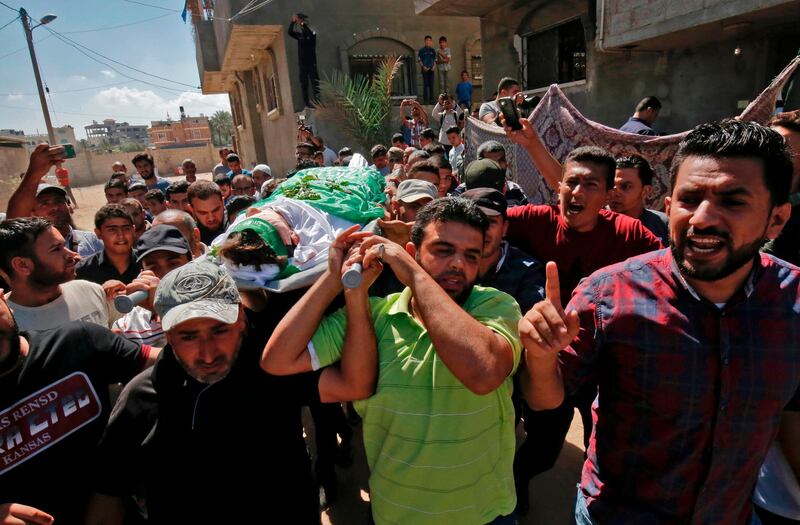 Palestinian mourners carry the body of Mumin Abu Ayeda, 15, who was killed during a protest at the Israel-Gaza border fence, during his funeral in Rafah in the southern Gaza Strip on September 20, 2018. The teenager was shot dead by Israeli fire in clashes near the border late the previous night, the health ministry in Gaza said. / AFP / SAID KHATIB
