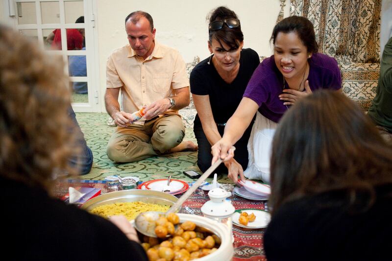 Al Rams, Ras Al Khaimah, United Arab Emirates - July 17 2013 - Expats serve themselves Gaymat as they attend their first Iftar at Fatima Bisher's (not shown) home in Al Rams, Ras Al Khaimah. The event was hosted by the Al Qasimi Foundation, which is based in RAK. For story by Rym Ghazal.  (Razan Alzayani / The National)  *** Local Caption ***  RA0718_expat_iftar_RAK012.jpg