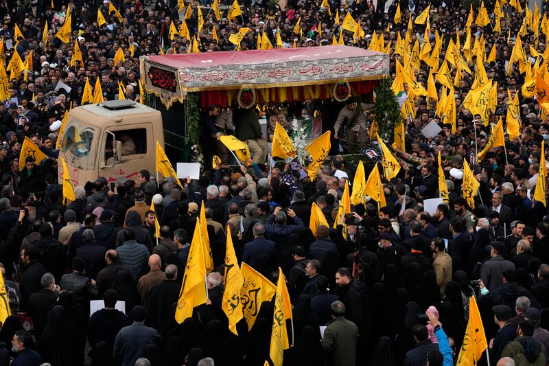 Mourners in Tehran surround a vehicle carrying the flag-draped coffin of Mousavi. AP Photo