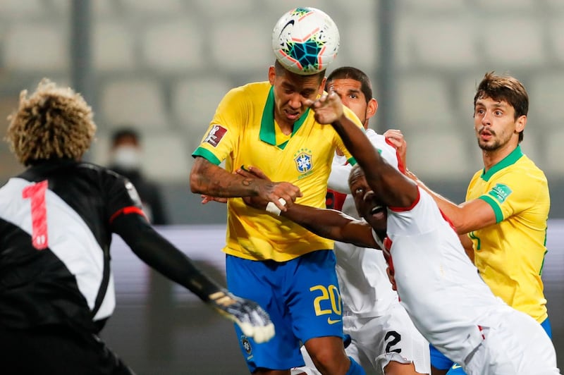 Brazil's Roberto Firmino heads the ball next to Peru's Luis Advincula for teammate Richarlison to score. AFP