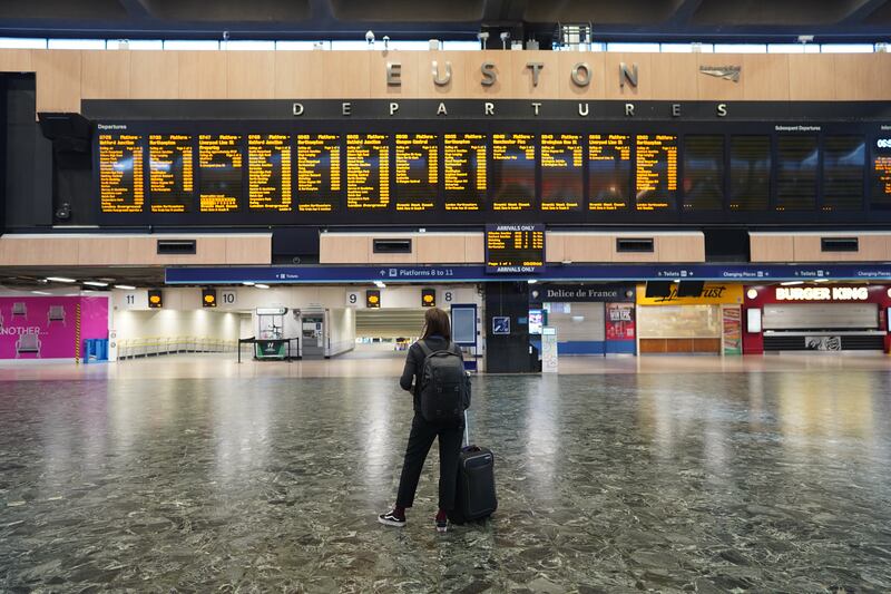 A passenger surveys departure boards at an empty Euston station in London. On Tuesday, the UK ground to a halt as the most extensive rail strikes in 30 years took place. PA