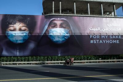 epa08362622 A motorist drives past an awareness campaign billboard over the ongoing pandemic of the Covid-19 disease caused by the SARS-CoV-2 coronavirus, in Dubai, United Arab Emirates, 14 April 2020. Awareness boards were erected in Dubai to urge citizens to wear a protection mask and stay home. Dubai authorities on 04 April announced the extension of the sterilization program to 24 hours a day for two weeks due to the ongoing pandemic of the Covid-19 disease.  EPA/MAHMOUD KHALED