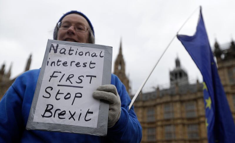 An anti Brexit campaigner holds a banner outside Parliament in London, Wednesday, March 27, 2019. British lawmakers were preparing to vote Wednesday on myriad options for leaving the European Union as they sought to end an impasse following the overwhelming defeat of the deal negotiated by Prime Minister Theresa May. (AP Photo/Kirsty Wigglesworth)