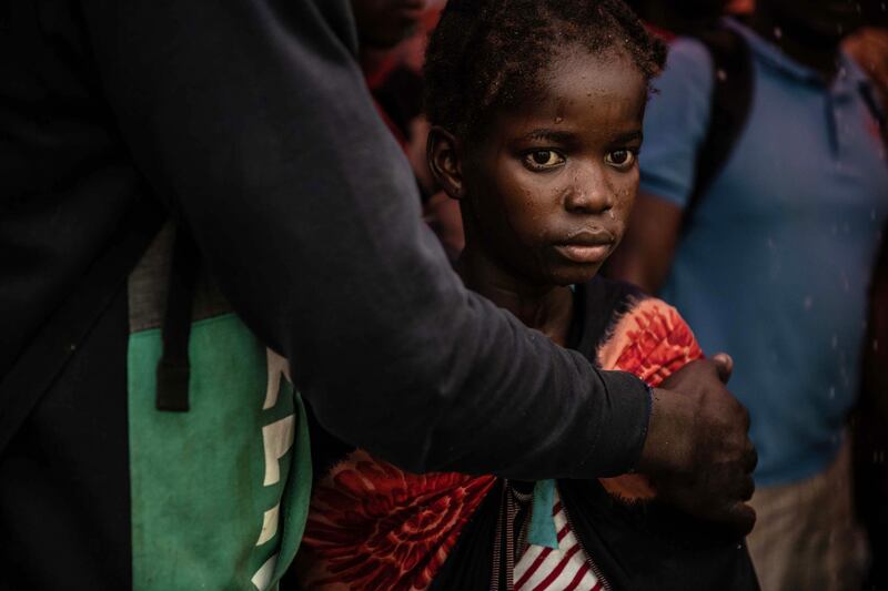 A young girl stares into the distance as people from the town of Buzi unload at Beira Port. Getty Images