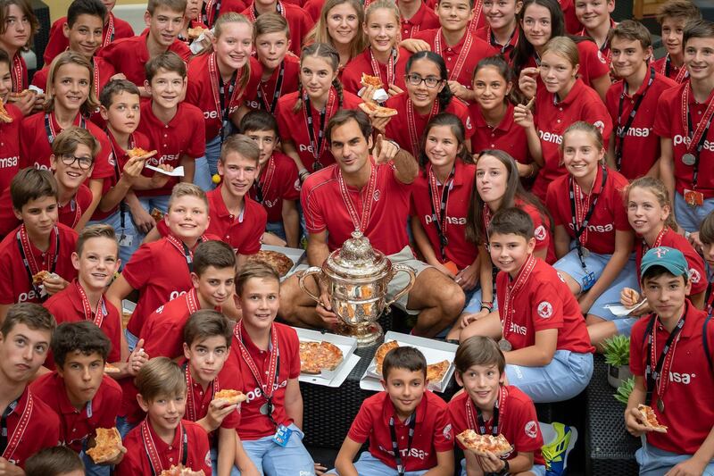 Roger Federer poses with ball kids after winning the Swiss Indoors tennis tournament in Basel on Sunday, October 27. AFP