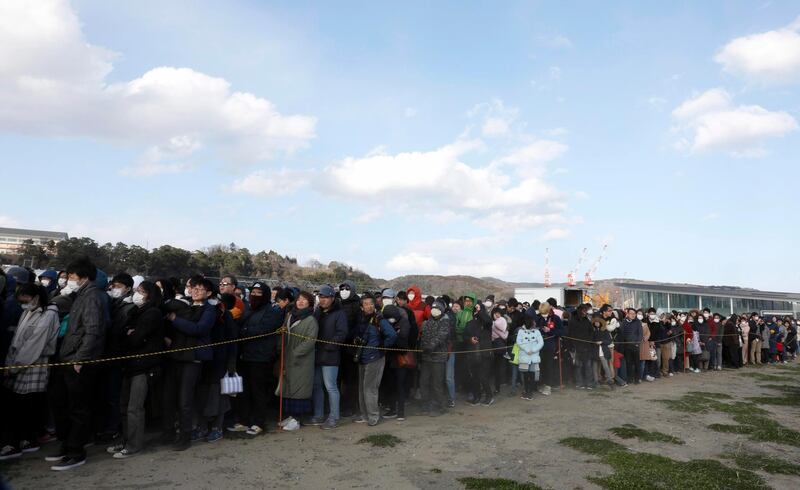 People in a queue to see the Olympic flame on a cauldron displayed at Ishinomaki Minamihama Tsunami Recovery Memorial Park. EPA