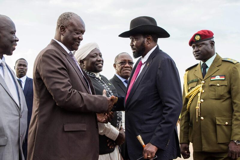 South Sudan's president Salva Kiir (2ndR) and Minster of Defence Kuol Manyang Juuk (2ndL) shake hands as Kiir arrives from Sudan's capital Khartoum at Juba Internal Airport in Juba, South Sudan, on June 27, 2018.  Kiir and his arch-foe Riek Machar agreed to a "permanent" ceasefire to take effect within 72 hours, raising hopes of an end to four-and-a-half years of war. / AFP / Akuot Chol
