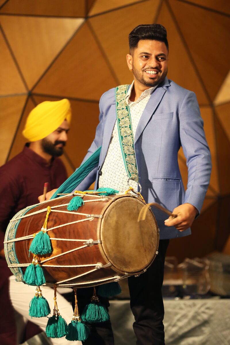 A drummer playing a dhol at the anniversary party.