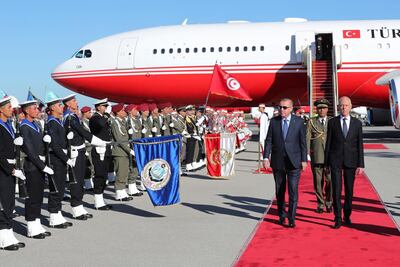 Turkey's President Recep Tayyip Erdogan, left, Tunisian President Kais Saied, right, inspect a military honour guard at the airport, in Tunis, Tunisia, Wednesday, Dec. 25, 2019. Erdogan with top Turkish officials is on an unannounced visit to Tunisia to meet Saied. (Turkish Presidency via AP, Pool)