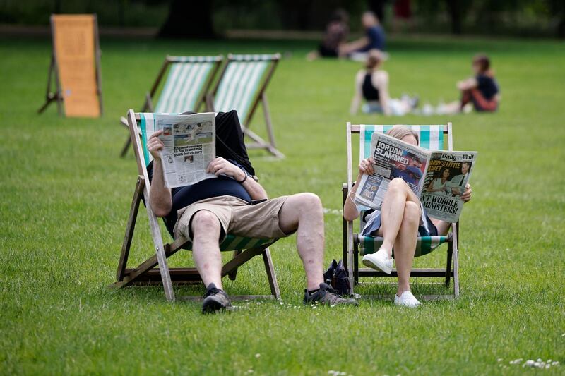 People sit in deck chairs as they enjoy the sunshine in St James's Park in central London. AFP