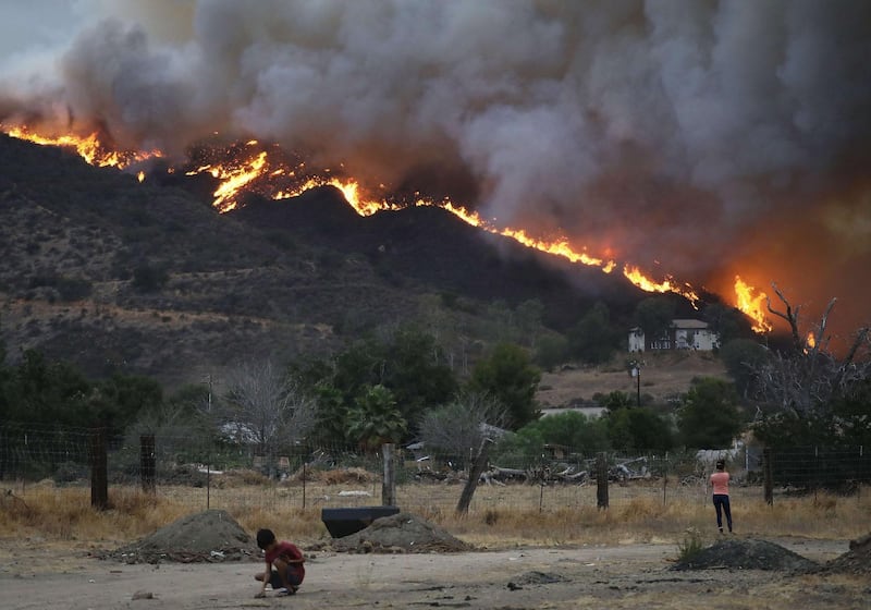 People gather as wildfire burns near homes in Lake Elsinore, California.  Getty Images/AFP