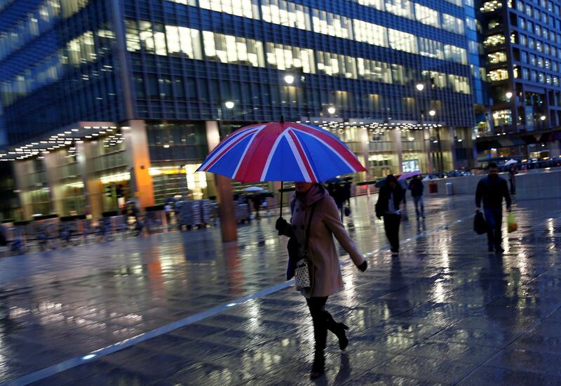 FILE PHOTO: Workers walk in the rain at the Canary Wharf business district in London, November 11, 2013. REUTERS/Eddie Keogh/File Photo