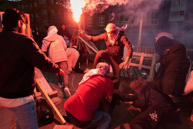 Masked men with flares attack the Gaza protest camp on the University of Amsterdam campus. Getty Images