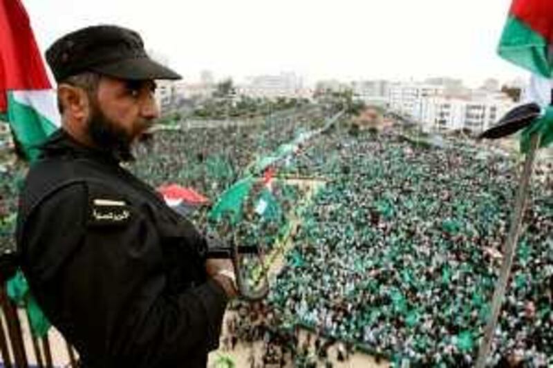 A Palestinian Hamas security officer oversees Hamas supporters attending a rally to mark the 22nd anniversary of the group's founding in Gaza City, Monday, Dec. 14, 2009. Tens of thousands of Hamas supporters thronged downtown Gaza City Monday to mark the 22nd anniversary of the group's founding, in a massive display that showed the Islamic militants still enjoy broad support despite years of rule that have led to war, poverty and isolation. (AP Photo/Hatem Moussa) *** Local Caption ***  JRL108_MIDEAST_ISRAEL_PALESTINIANS.jpg