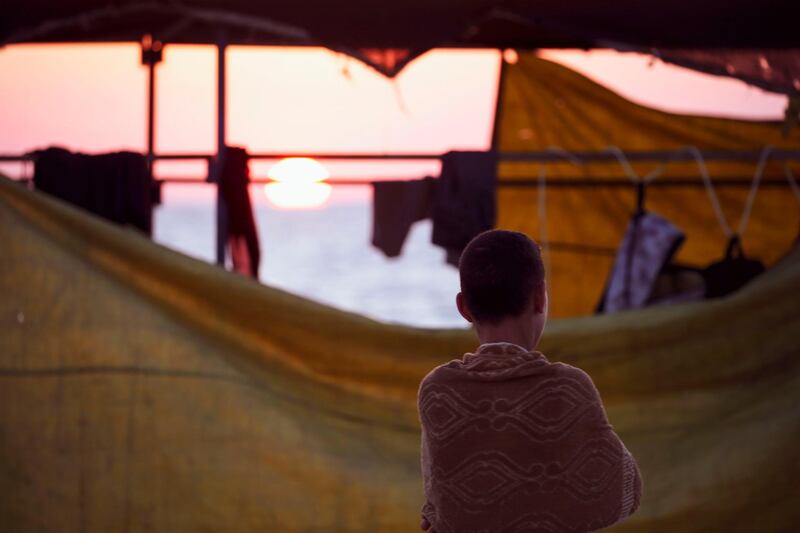 A boy is pictured at the sunset on the beach in Gaza on July 3, 2020. / AFP / MOHAMMED ABED
