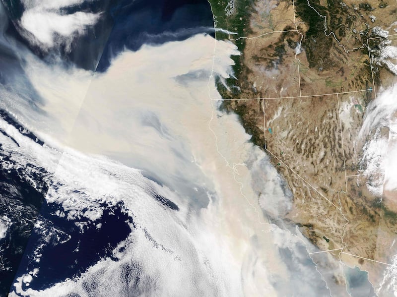 This NASA Earth Observatory image shows this natural color image of thick smoke plumes streaming west from a long line of intense fires in Washington state, Oregon and California. AFP