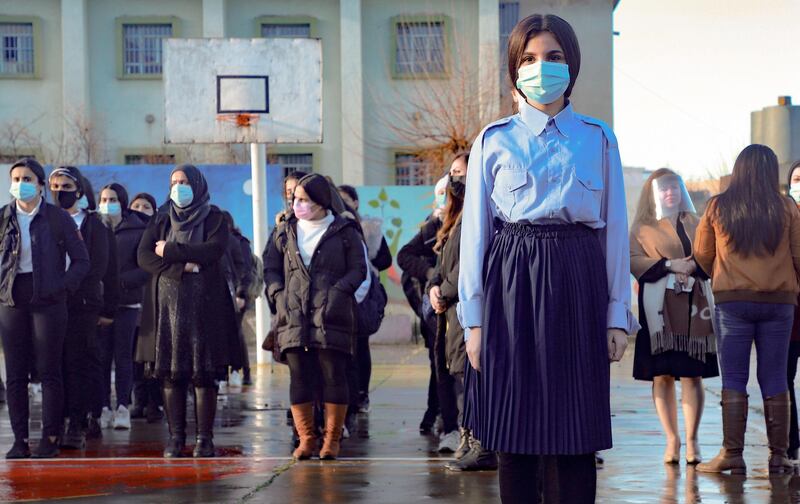 Mask-clad Iraqi Kurdish students gather in the courtyard of their school in the northeastern city of Sulaimaniyah, on the first day of  reopening. Schools were shut down in the region for three months due to the coronavirus pandemic. Grade 12 students returned to class last month. AFP