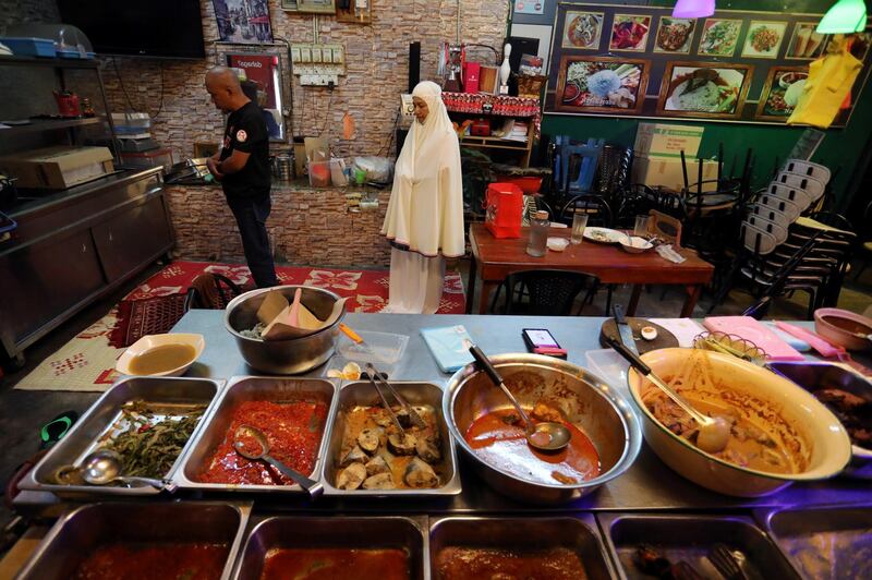 A Muslim family pray inside their restaurant during the holy month of Ramadan, amid the coronavirus disease (COVID-19) outbreak, in Selayang, Malaysia . REUTERS