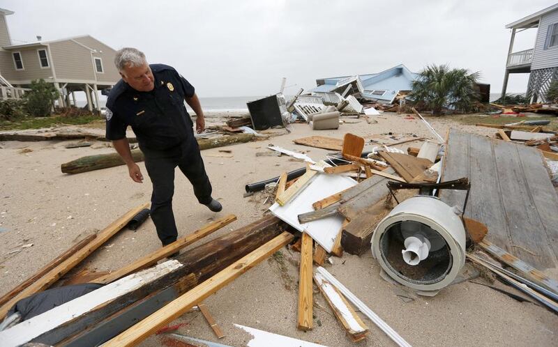 Edisto Beach chief of Police George Brothers surveys the damage done to homes along Palmetto Boulevard after Hurricane Matthew hit the tiny beach community in South Carolina. The four-lane boulevard was covered with sand. Mic Smith / AP Photo