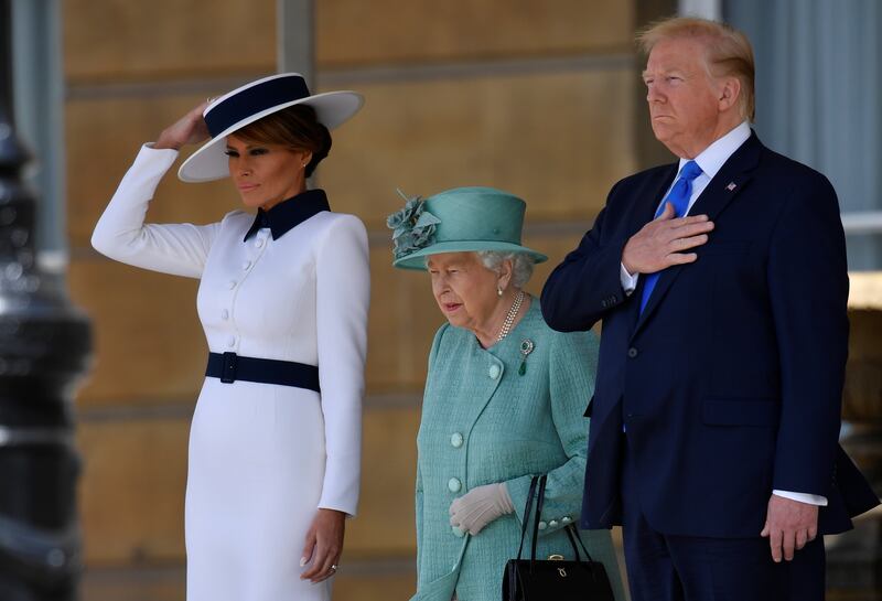 Britain's Queen Elizabeth II (C) stands with US President Donald Trump (R) and US First Lady Melania Trump (L) as they listen to the US national anthem during a welcome ceremony at Buckingham Palace in central London on June 3, 2019, on the first day of the US president and First Lady's three-day State Visit to the UK. Britain rolled out the red carpet for US President Donald Trump on June 3 as he arrived in Britain for a state visit already overshadowed by his outspoken remarks on Brexit. / AFP / POOL / TOBY MELVILLE
