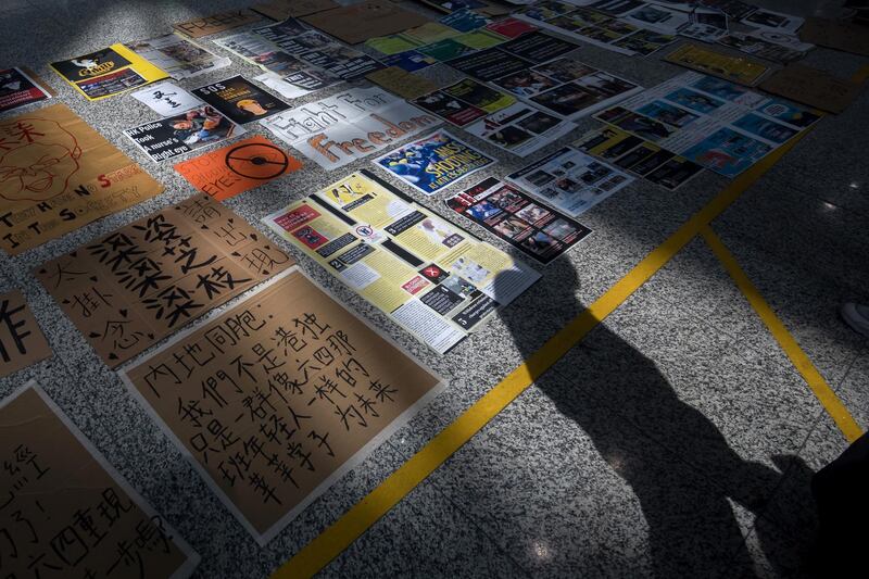 Placards and signs sit on the arrival hall floor at Hong Kong International Airport. Bloomberg