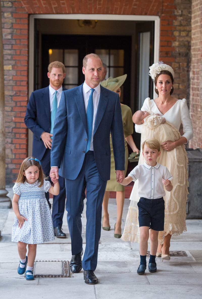 Princess Charlotte and Prince George hold the hands of their father as they arrive at the Chapel Royal, St James's Palace, London, for the christening of their brother, Prince Louis, who is being carried by their mother, in July 2018.