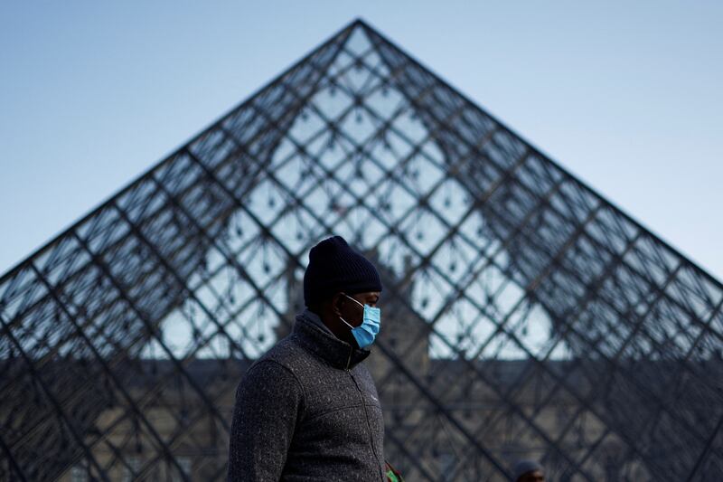 A man wearing a face mask walks past the Louvre Pyramid, at the Louvre museum, in French capital Paris. Reuters