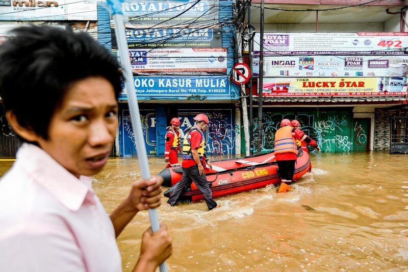Members of a rescue team prepare an inflatable boat to evacuate locals as floods hit the Jatinegara area of Indonesia. Reuters