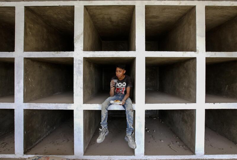 A man rests as crypts are adapted for hundreds of unidentified bodies at the municipal pantheon in El Salto, Jalisco State, Mexico.  A wave of violence linked to powerful drug cartels has sent the number of missing persons in the country soaring to more than 36,000. Ulises Ruiz/AFP
