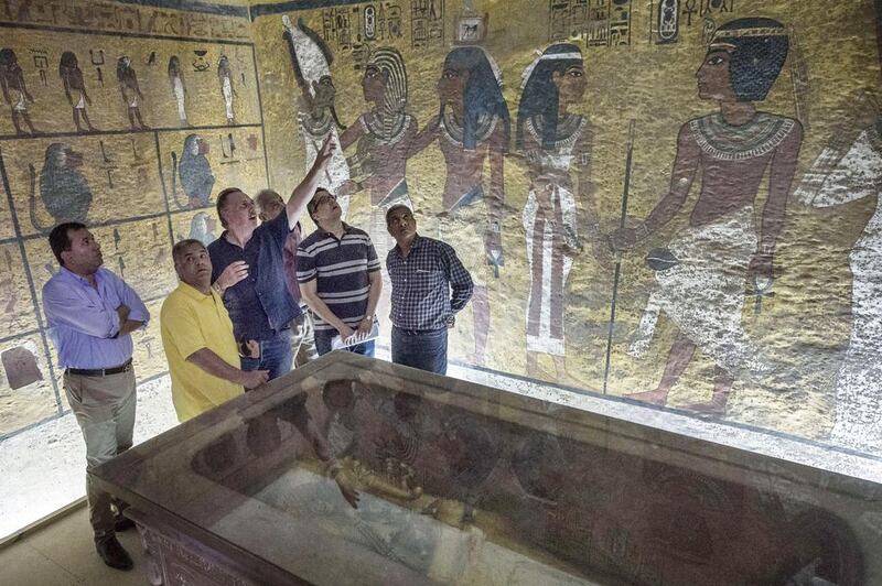 Egypt’s minister of antiquities, Mamdouh Al Damati, second left, listens to British Egyptologist Nicholas Reeves, third left, near the sarcophagus of King Tutankhamun in his burial chamber in the Valley of the Kings, close to Luxor on September 28, 2015. Nicholas Reeves believes the legendary Queen Nefertiti may be buried in a secret room adjoining Tutankhamun’s tomb. Khaled Desouki/AFP Photo