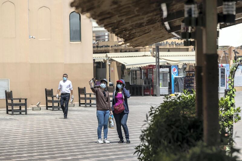 DUBAI, UNITED ARAB EMIRATES. 15 JUNE 2020. STANDALONE. Bur Dubai life during COVID-19.  Two woman take a selfie while walking along the Creek. (Photo: Antonie Robertson/The National) Journalist: None. Section: National.