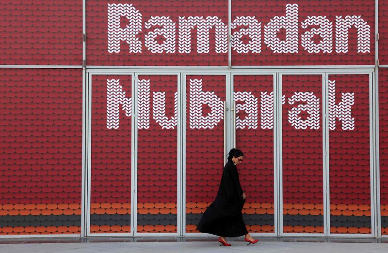 A woman walks past an installation with the message Ramadan Mubarak (blessed), on May 3, 2021 in Dubai's Design District, during the Muslim holy fasting month of Ramadan. / AFP / GIUSEPPE CACACE
