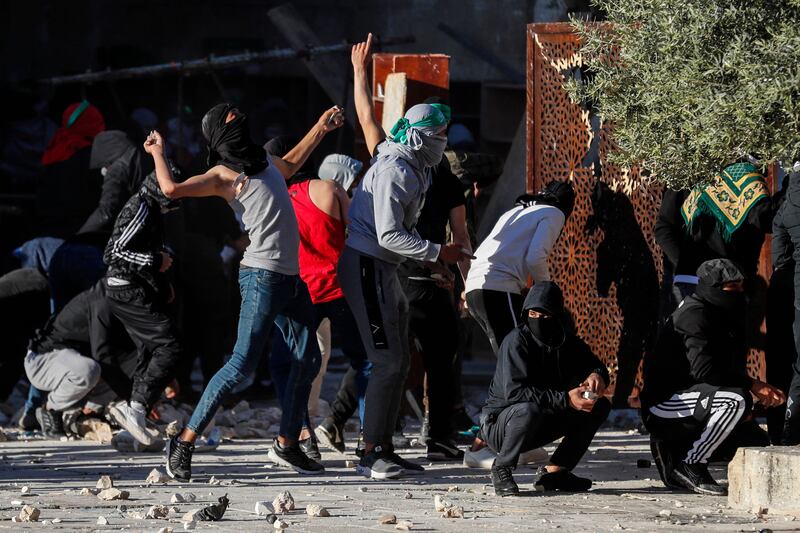 Palestinian demonstrators throw rocks at Israeli police at Jerusalem's Al Aqsa Mosque compound. AFP