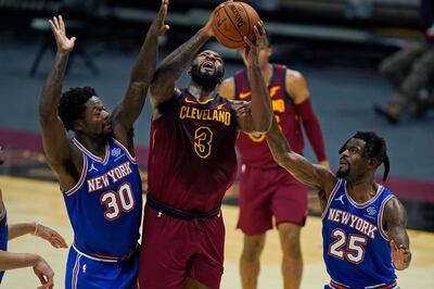 Cleveland Cavaliers' Andre Drummond (3) drives to the basket against New York Knicks' Julius Randle (30) and Reggie Bullock (25) during the first half of an NBA basketball game Friday, Jan. 15, 2021, in Cleveland. (AP Photo/Tony Dejak)