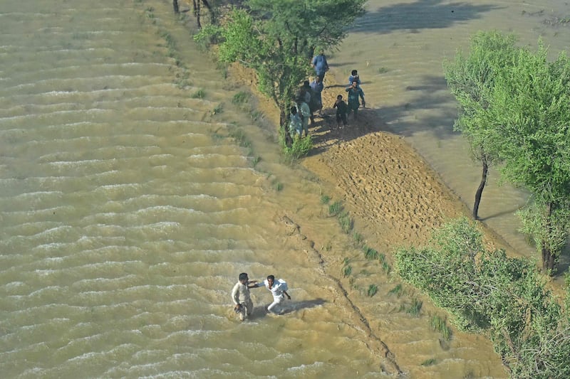 People wait for relief supplies being dropped by Pakistan army helicopters. AFP