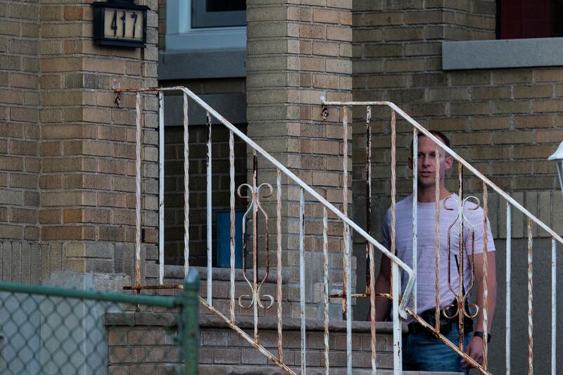 A plain-clothed police officer stands near the entrance of the building where Mr Matar lives in Fairview, New Jersey. Reuters