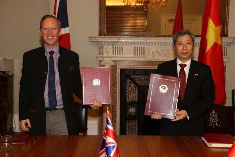 British Ambassador to Vietnam, Gareth Ward (L, front) and Vietnamese Ambassador to the UK, Tran Ngoc An show documents after they signed the UK-Vietnam Free Trade Agreement at the Foreign, Commonwealth and Development Office (FCDO) in London, Britain December 29, 2020. UK Government/Handout via REUTERS. ATTENTION EDITORS - THIS IMAGE HAS BEEN SUPPLIED BY A THIRD PARTY. NO RESALES. NO ARCHIVES.