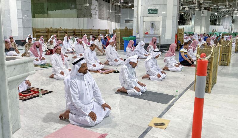 Muslim worshippers perform the "Tarawih" nightly prayer during the holy month of Ramadan, while keeping their distance amid the COVID-19 pandemic, at the Grand Mosque, Islam's holiest site, in the Saudi city of Mecca, late on May 8, 2020. - Saudi Authorities allowed for a limited number of worshippers to enter the Grand Mosque to perform prayers during Ramadan, amid unprecedented bans on family gatherings and mass prayers due to the novel coronavirus (COVID-19) pandemic. (Photo by STR / AFP)